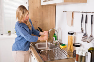 woman using plunger that needs plumbing system repair in emmaus pennsylvania