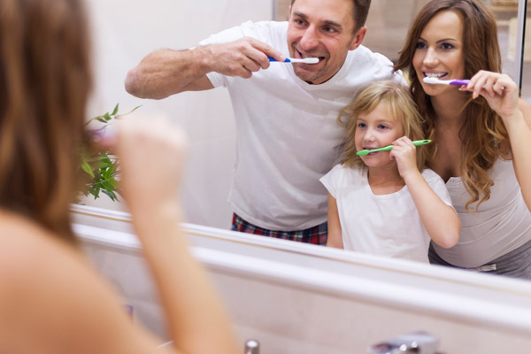 image of fami;y brushing teeth with the faucet off to conserve water