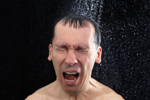 image of a man taking a cold shower due to broken water heater