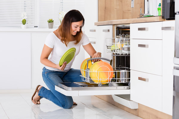 image of a woman using a dishwasher