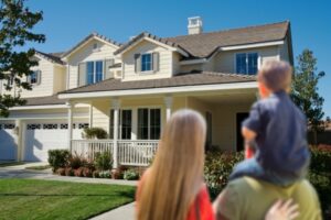 family in the foreground looking at a house for sale