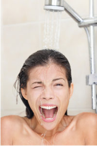 woman dealing with a cold shower from faulty water heater