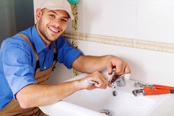 image of a plumber repairing a sink