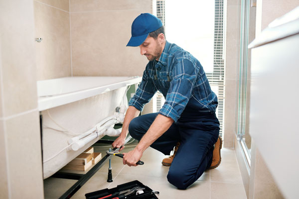 plumber performing bath tub clogged drain repair