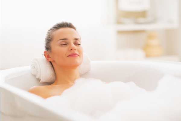 woman using bath bombs in the bath tub