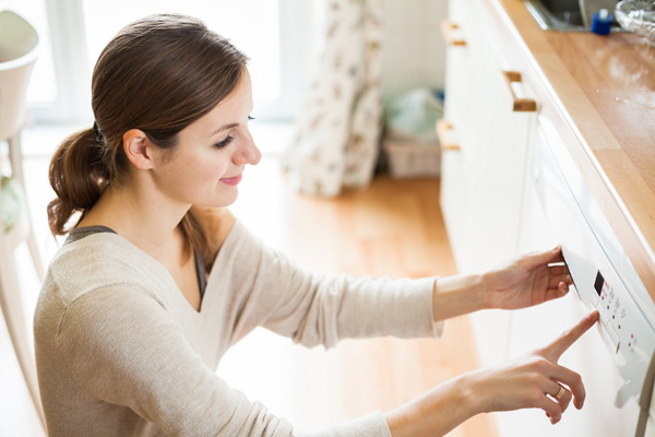 homeowner setting dishwasher to energy efficient setting
