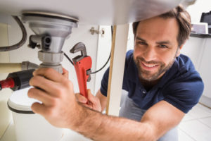 image of plumber working on bathroom sink