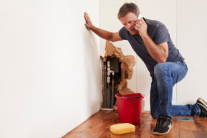 homeowner dealing with a burst water pipe