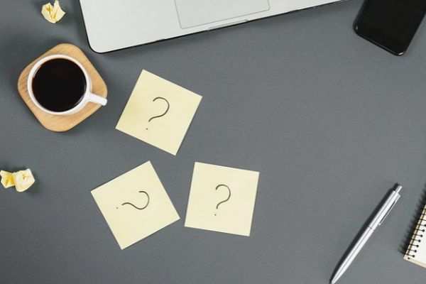 question marks on sticky notes beside a coffee cup depicting Low Water Pressure in House FAQs