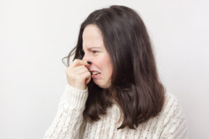 homeowner plugging nose due to kitchen sink drain smell