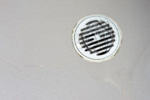 image of a drain with hair that is clogging bathtub drain