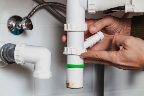 plumber dismantling sink pipes