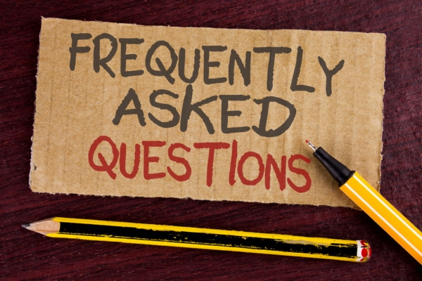 Frequently Asked Questions written on a cardboard depicting questions about how to find a good plumber