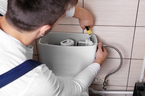 image of plumber repairing toilet