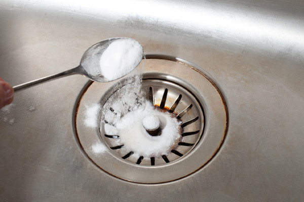 image of baking soda and kitchen sink depicting plumbing tricks