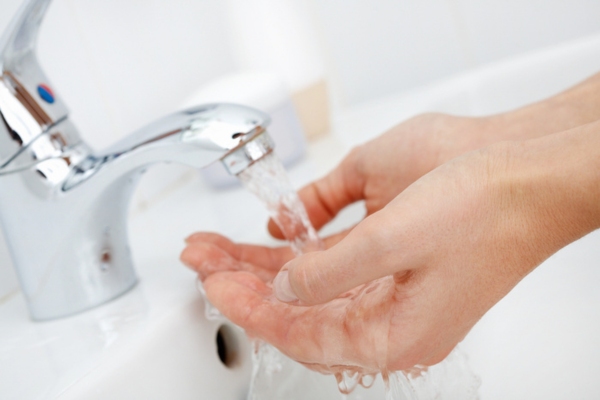 image of a woman's hand examining home water pressure from a faucet